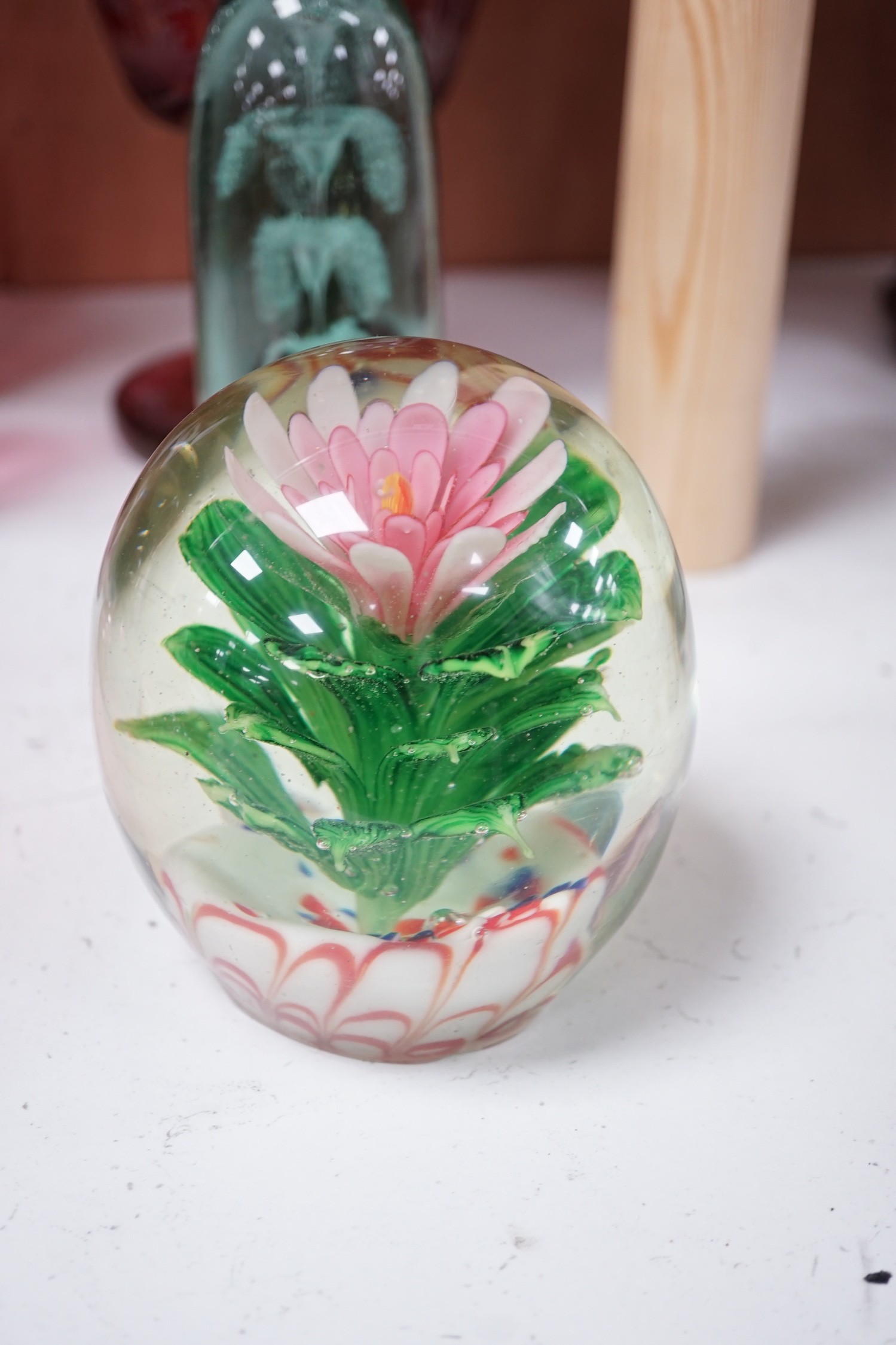 A collection of cranberry glass, a dump paperweight, another and a sweetmeat jar, tallest 28.5 cm